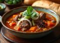 Bát bò kho với thịt bò mềm, cà rốt, hoa hồi, nước dùng đỏ cam, ăn kèm bánh mì