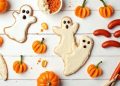 Mâm món ăn vặt Halloween cho bé: bánh quy hình ma và bí ngô, cam bí ngô mini, chuối ma, xúc xích ngón tay